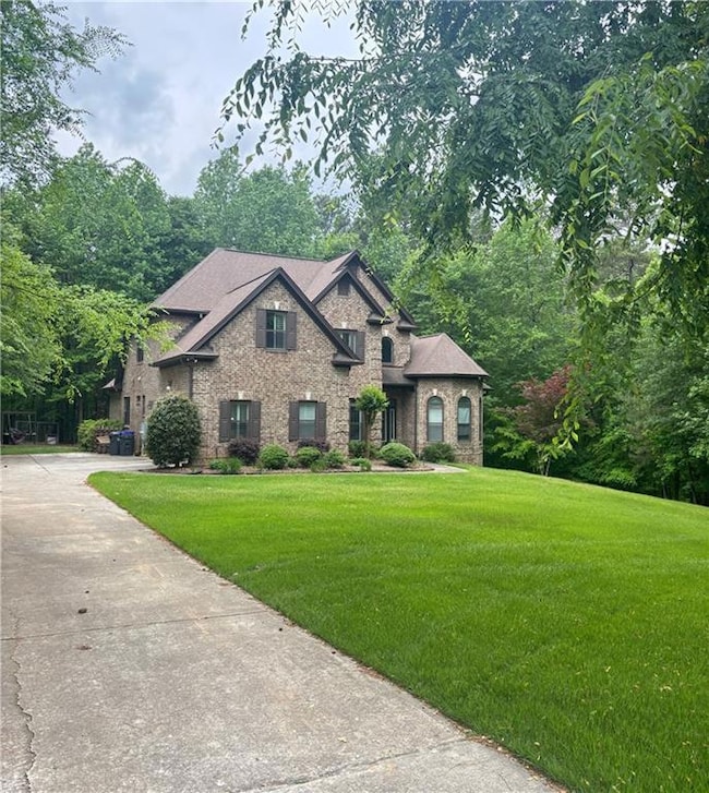 View of front of house with a front yard, brick si