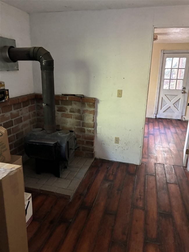Interior space featuring dark wood-type flooring and a wood stove