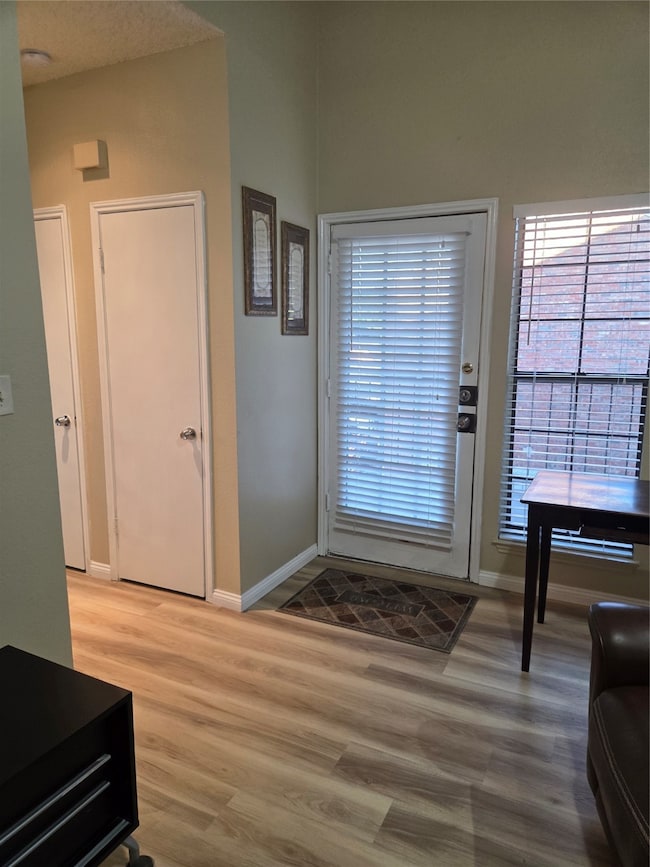Entryway with baseboards and light wood-type flooring