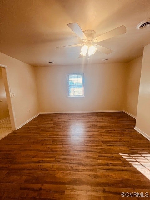 Empty room with visible vents, baseboards, wood fi