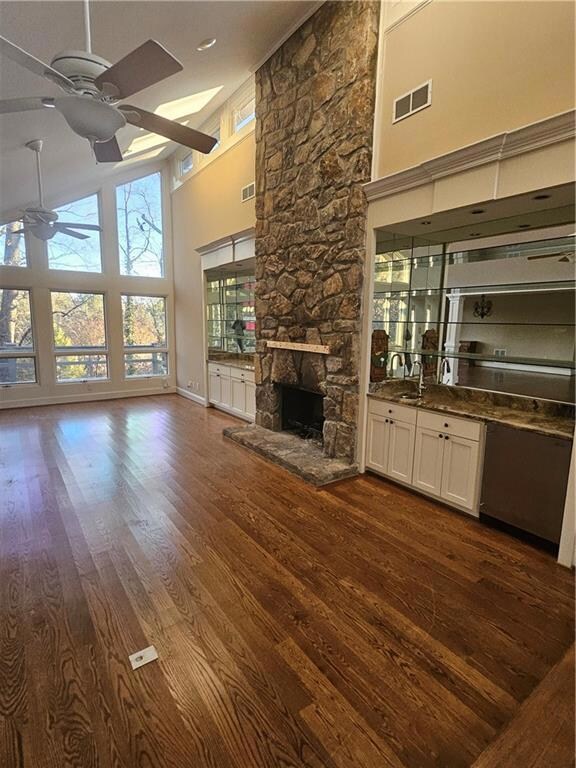 living room with a fireplace, a high ceiling, hard