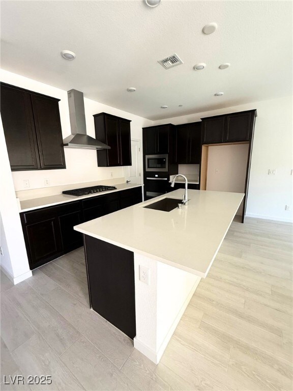 Kitchen featuring a kitchen island with sink, stai