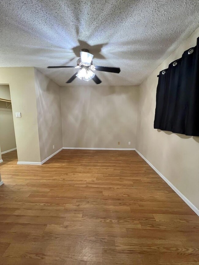 Empty room with a textured ceiling, ceiling fan, 