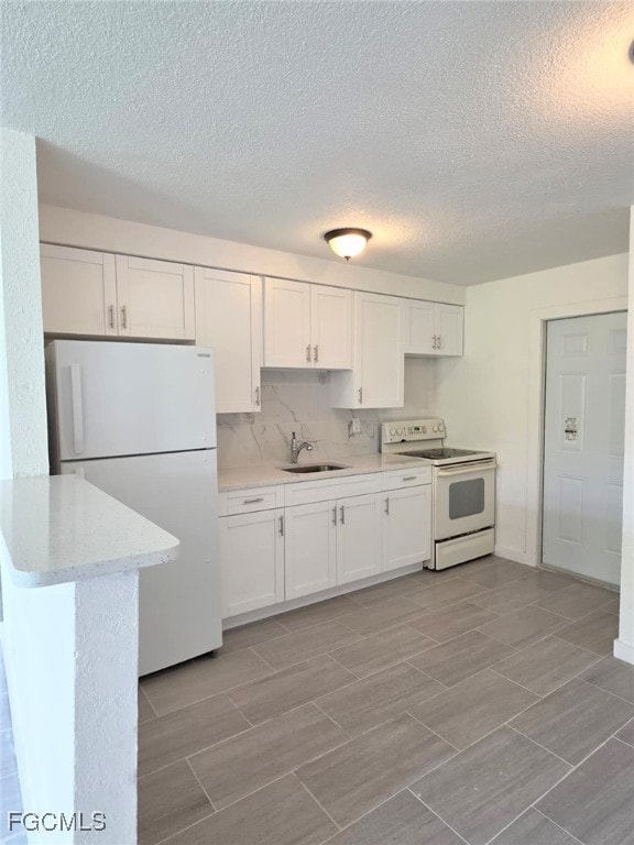 Kitchen with white appliances, white cabinets, a t