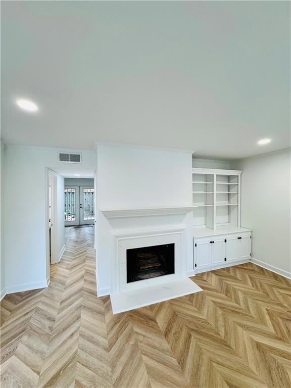 Unfurnished living room with baseboards, recessed lighting, a fireplace, and french doors