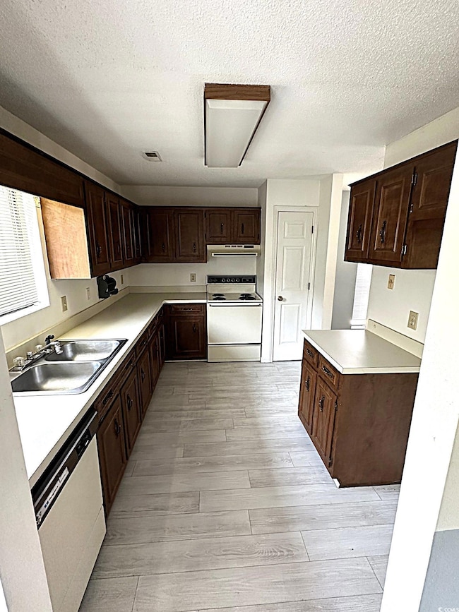 Kitchen featuring dark brown cabinetry, sink, range, and stainless steel dishwasher