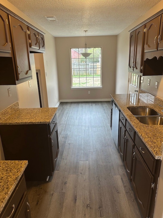 Kitchen featuring dark brown cabinetry, dishwasher