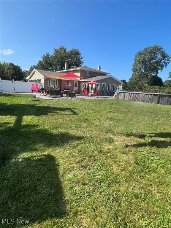 Rear view of property featuring a patio and a fenced backyard