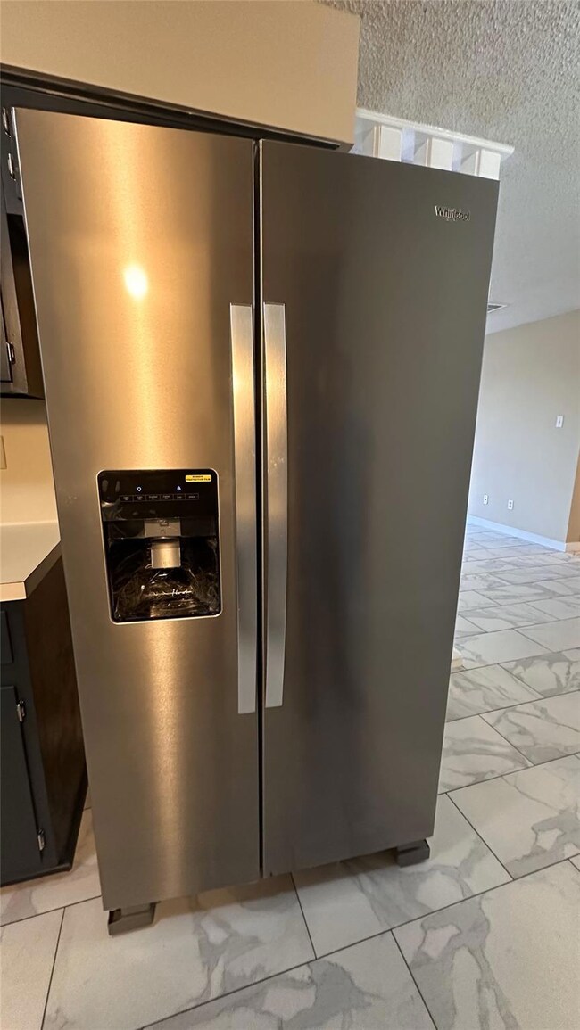 Kitchen view of stainless steel refrigerator with