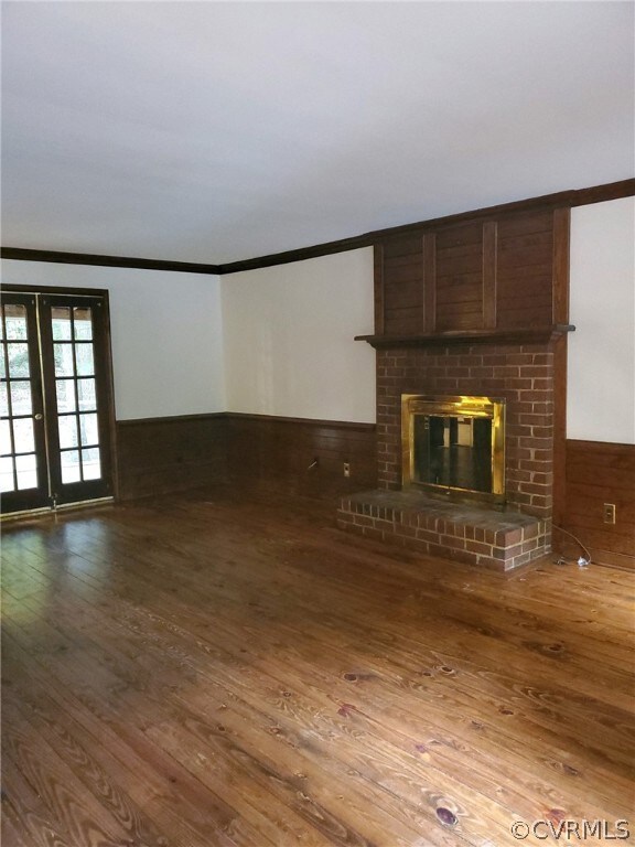Rustic den with brick fireplace and wood floors.