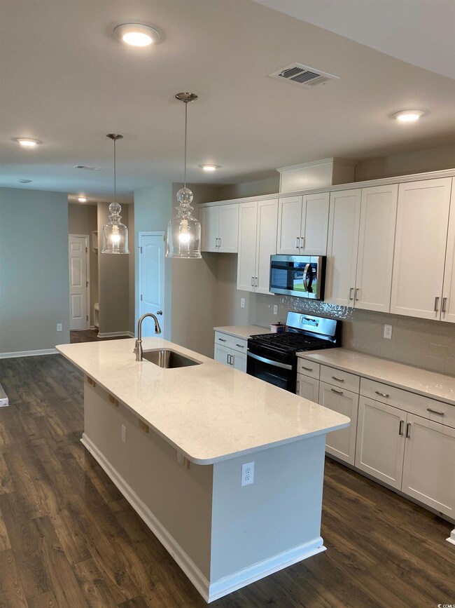 Kitchen featuring black range with gas cooktop, ta