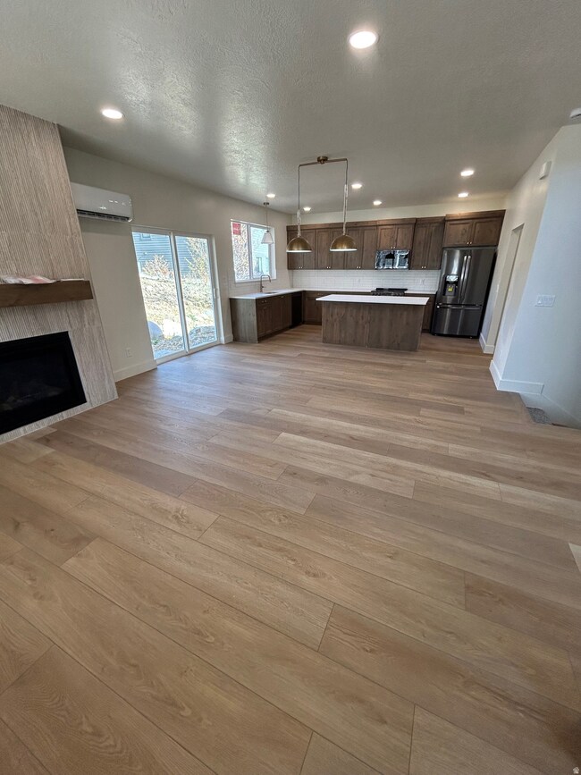 Kitchen featuring open floor plan, light countertops, recessed lighting, appliances with stainless steel finishes, and light wood-style floors
