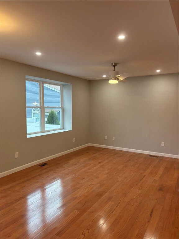 Spacious living room with recessed lighting and ceiling fan.