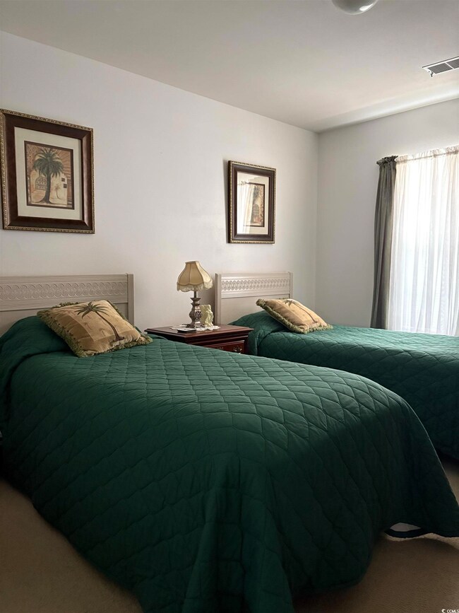 Bedroom with visible vents and carpet floors