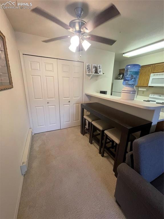Kitchen featuring ceiling fan, light colored carpe