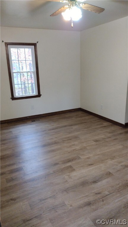Unfurnished room featuring ceiling fan and hardwoo