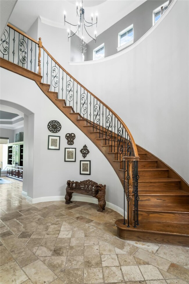 Stairway featuring stone tile flooring, a high ce