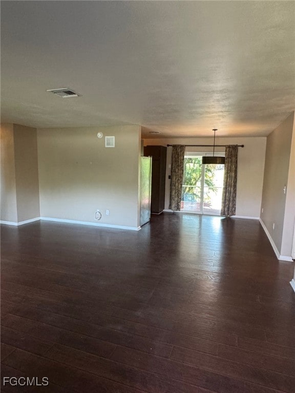 Open floor plan living room/ dining room with baseboards and dark laminate floors