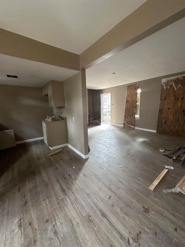 Unfurnished living room with wood finished floors and baseboards