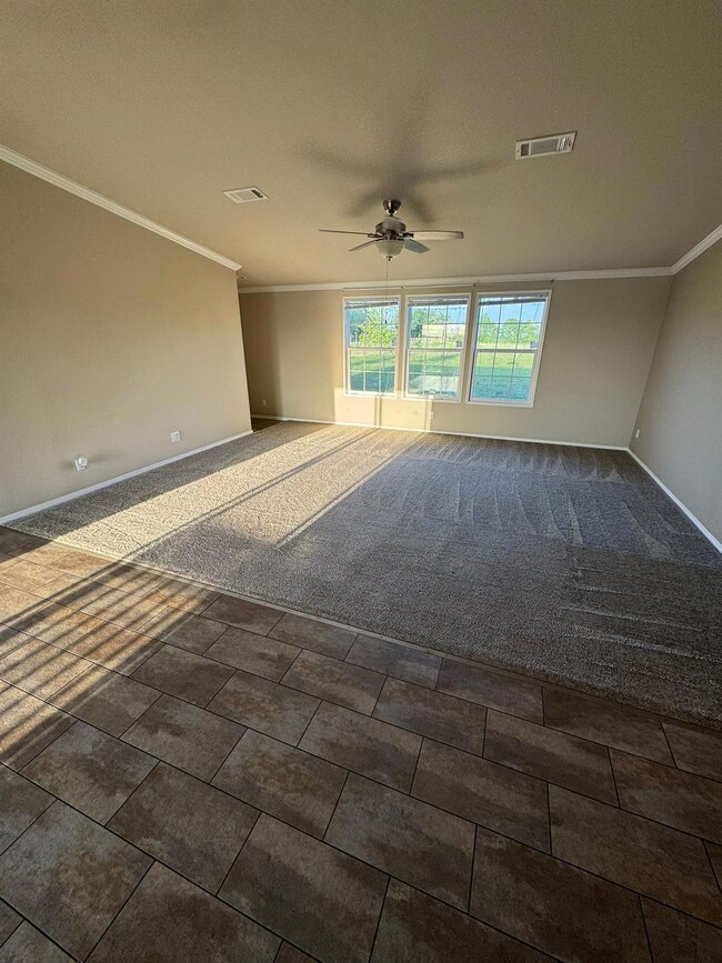Spare room featuring crown molding, baseboards, c