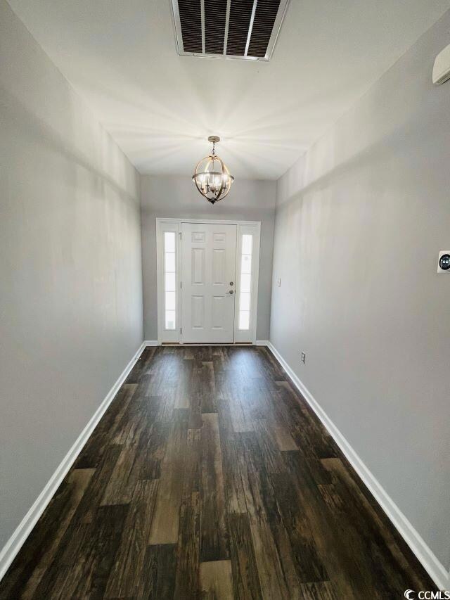 Entryway with a notable chandelier and hardwood / 