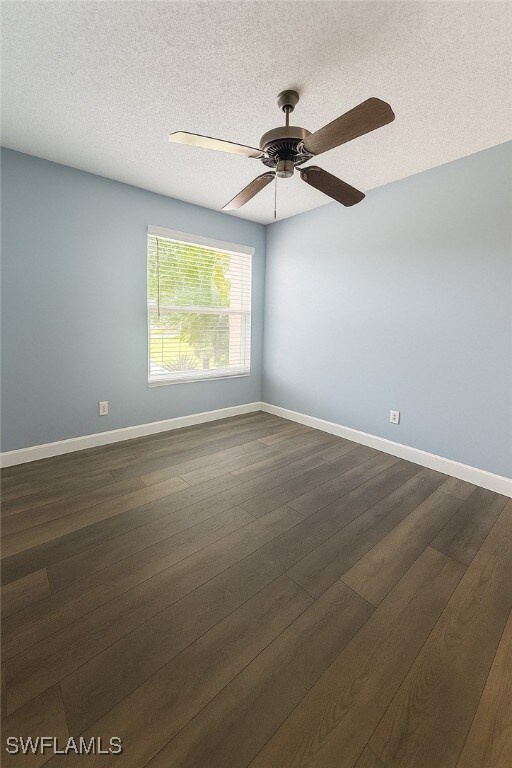 Spare room with a ceiling fan, dark LVP flooring,