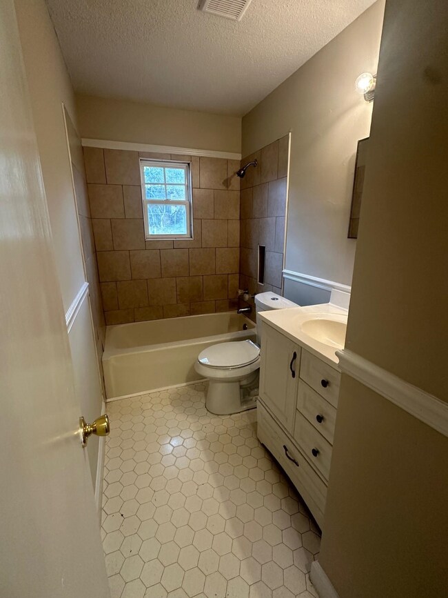 Full bathroom with tiled shower / bath, a textured