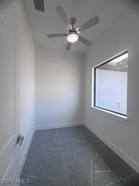 Spare room featuring dark marble finish floors, a