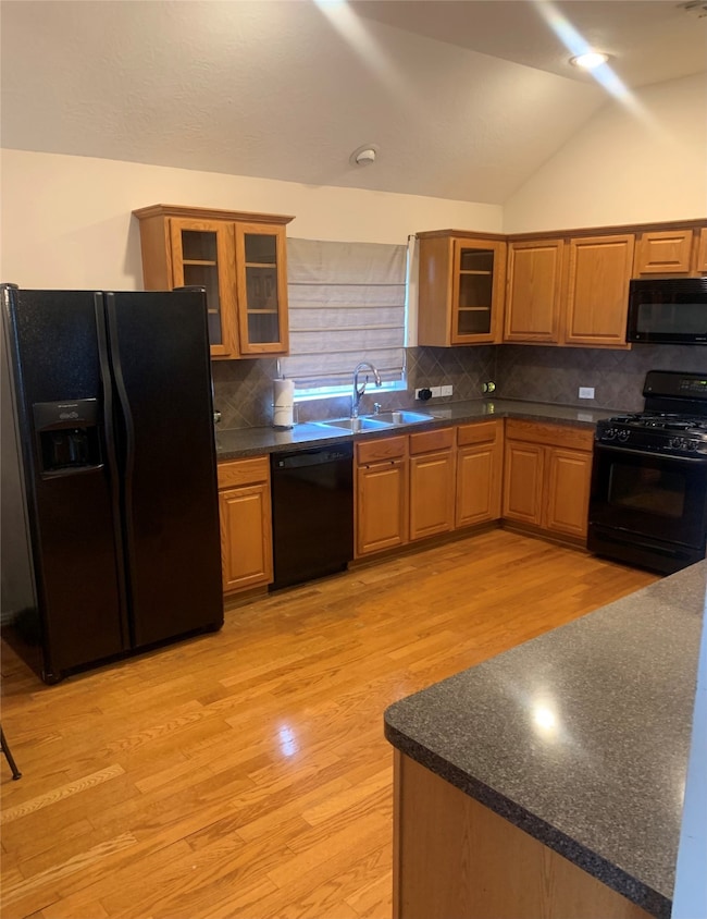 Kitchen complete with glass front custom cabinets and wood floors
