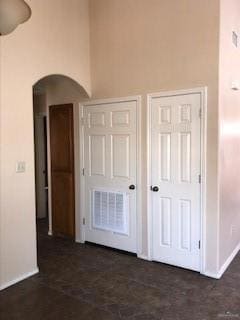 Empty room with ceiling fan and high vaulted ceiling