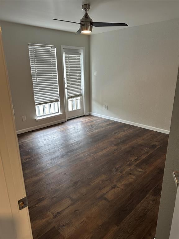 Unfurnished room with dark wood finished floors and ceiling fan