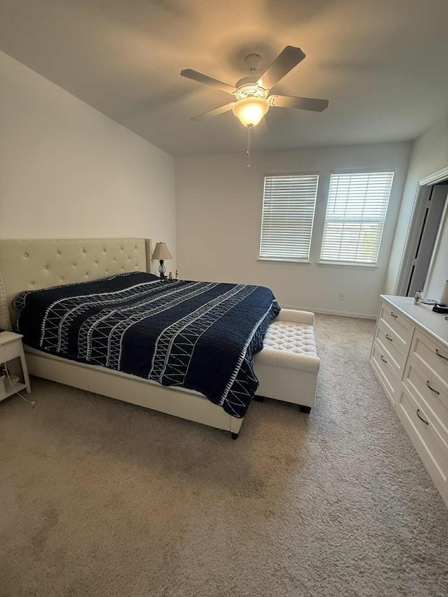 Bedroom featuring light carpet and a ceiling fan