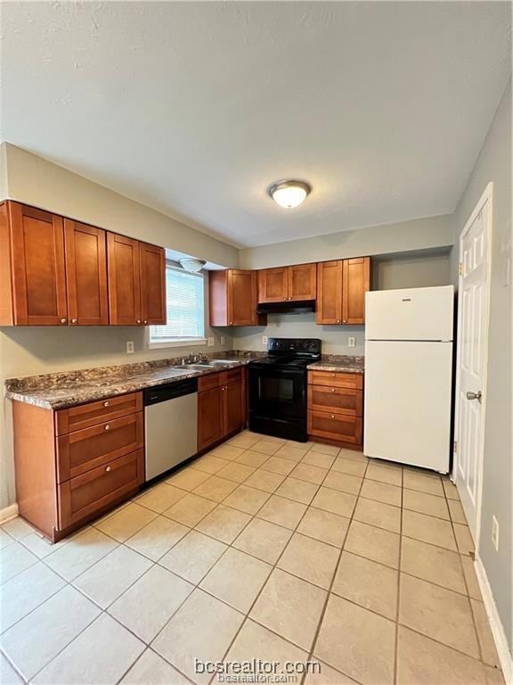 Kitchen featuring dishwasher, white fridge, black