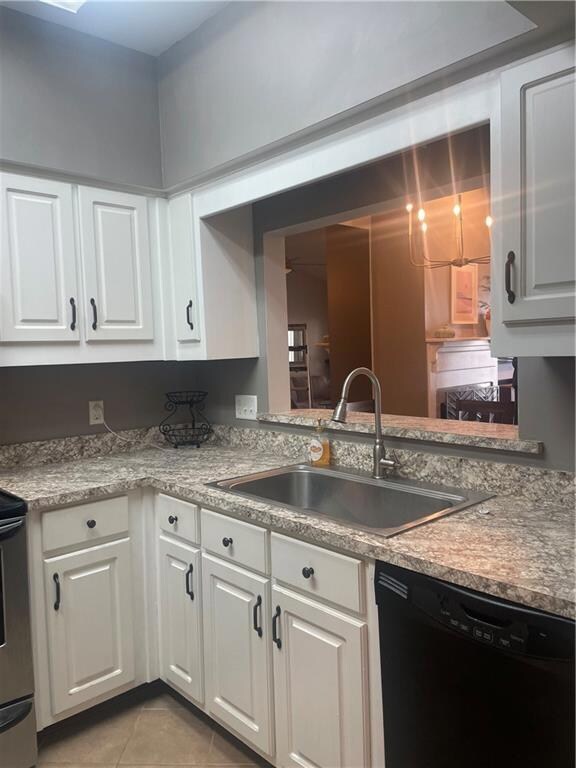 Kitchen with dishwasher, white cabinetry, range, and light tile patterned floors