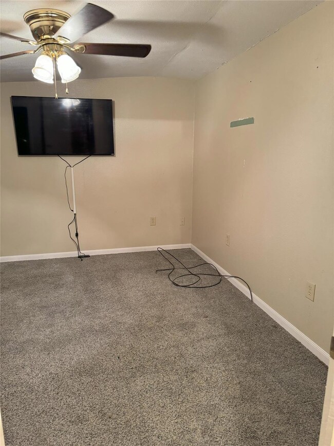Spare room featuring ceiling fan and carpet floori