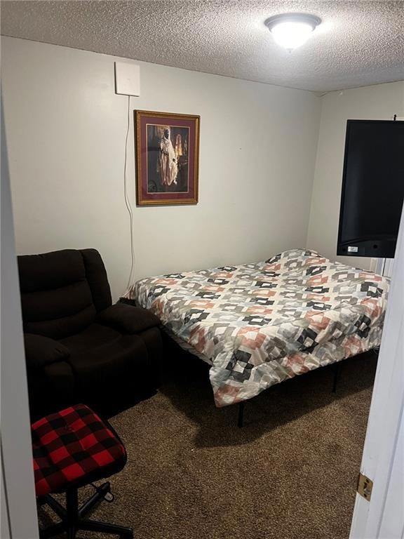 Carpeted bedroom featuring a textured ceiling