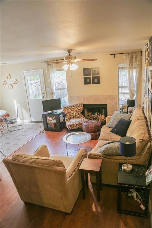 Living area with ceiling fan, a tiled fireplace, 