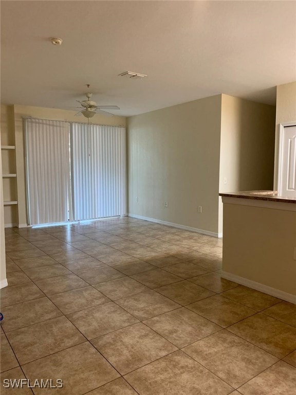 Unfurnished room featuring ceiling fan, light tile