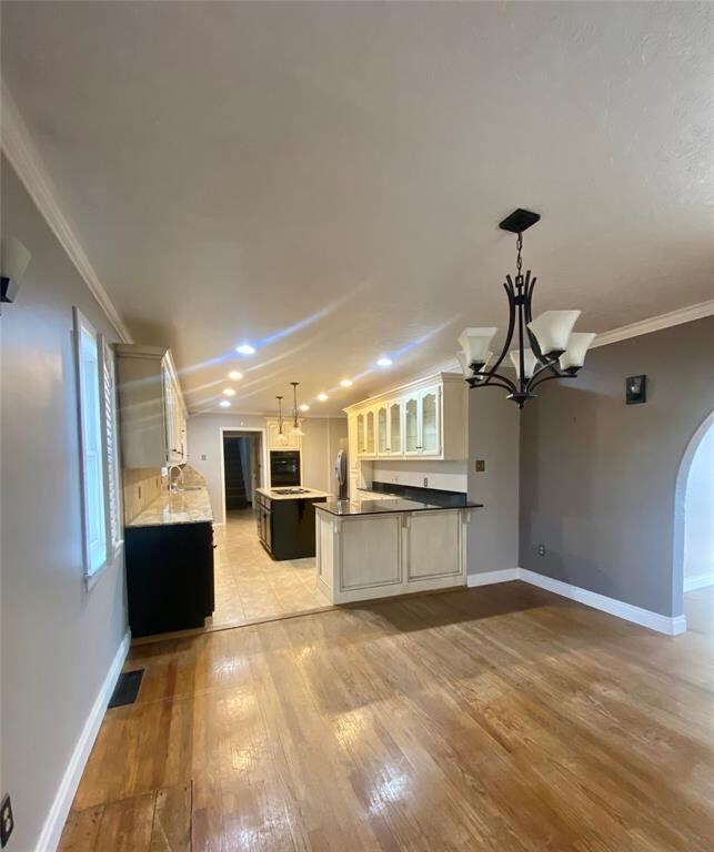Kitchen with ornamental molding, white cabinets, d