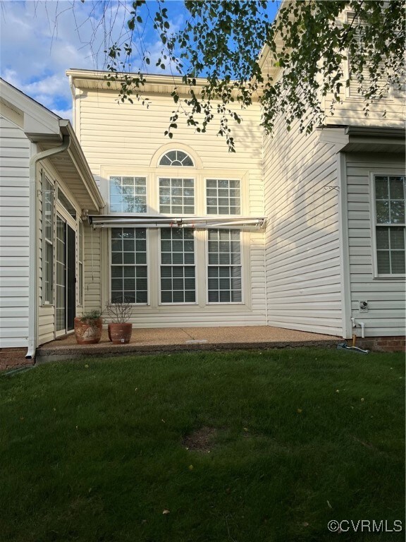 Back of property with a yard