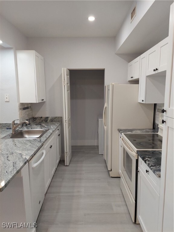 Kitchen with white cabinetry, white range oven, dishwasher, and recessed lighting
