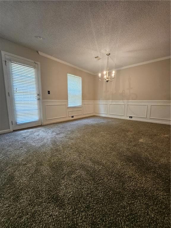 Carpeted  featuring a chandelier, ornamental molding & a textured ceiling