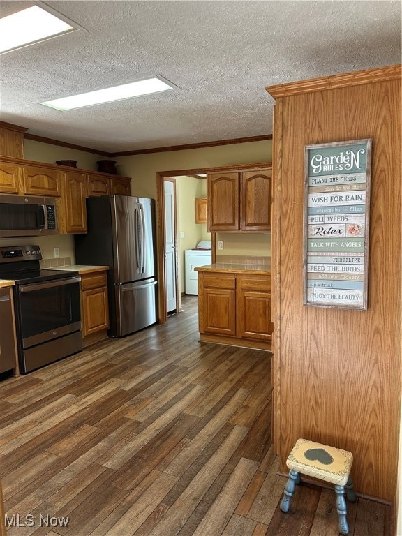 Kitchen featuring stove, Luxury Vinyl flooring, ornamental molding, brown cabinetry, and fridge
