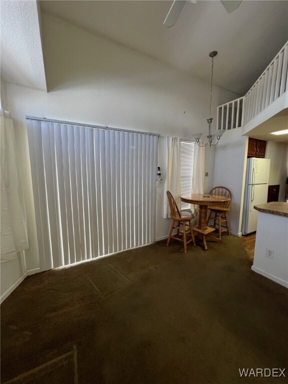 Dining area with ceiling fan with notable chandeli