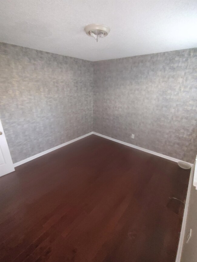Unfurnished room with baseboards and dark wood-typ