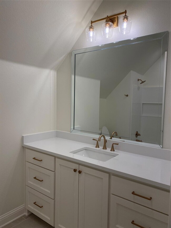 Bath featuring vaulted ceiling, tile patterned flo