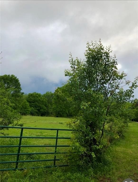 View of gate featuring a lawn and a rural view