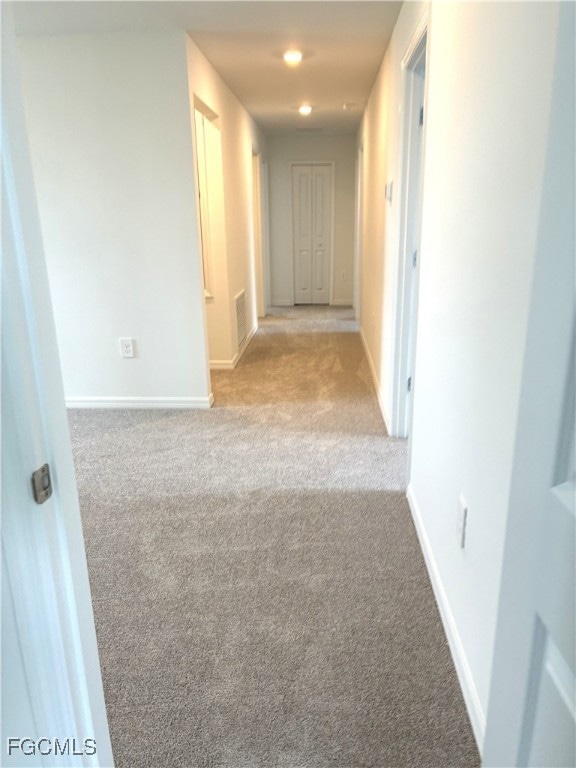 Corridor with carpet and baseboards
