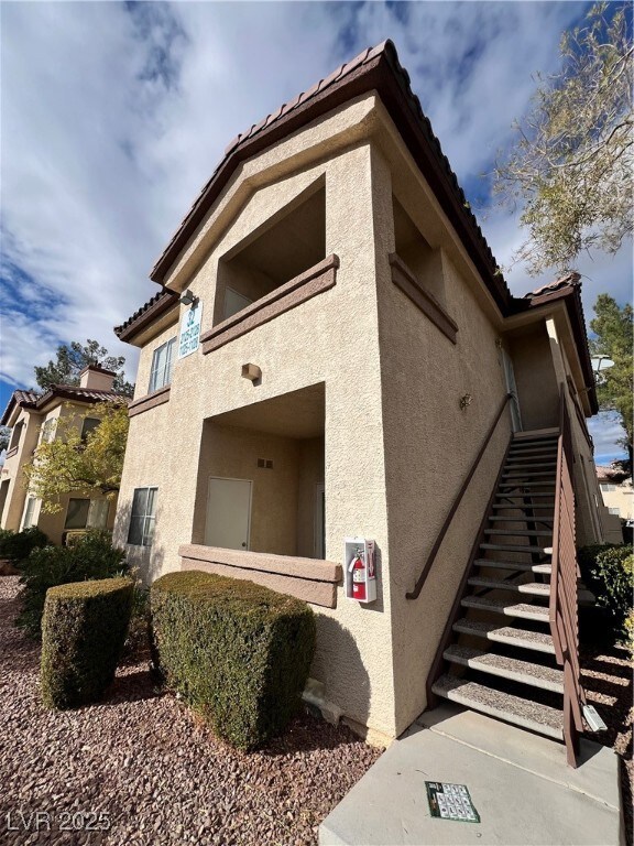 View of home's exterior featuring stairs, stucco s