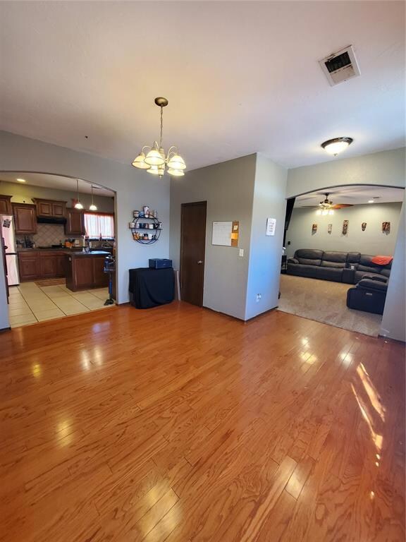 Unfurnished living room featuring ceiling fan with